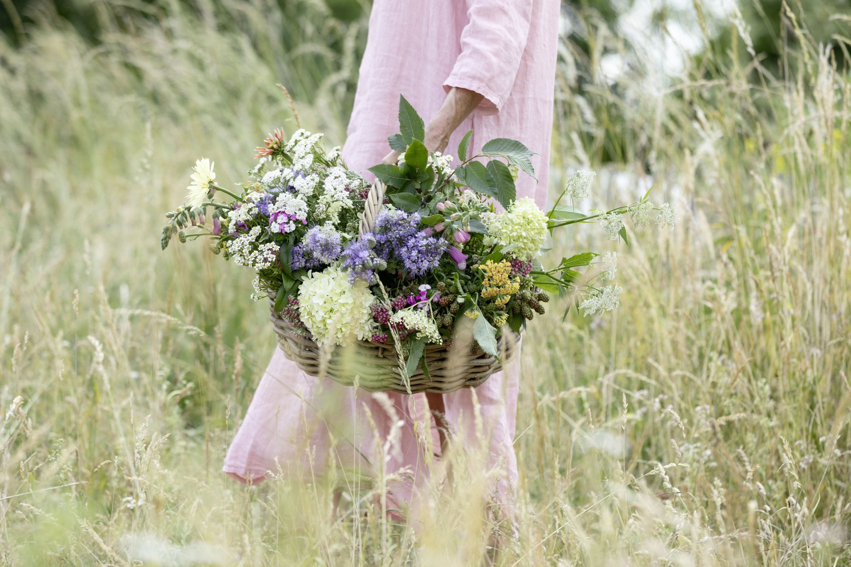 Frau mit Blumenkorb im Garten
